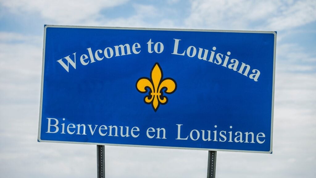 Louisiana highway sign on a busy road, representing the state’s high uninsured motorist rate.
